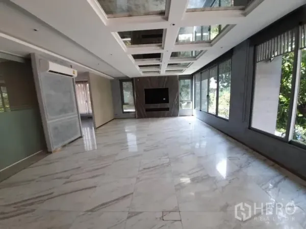 Office Space for rent in Khlong Toei, Bangkok - Large open office with marble floors, coffered ceiling and full-height windows overlooking greenery.
