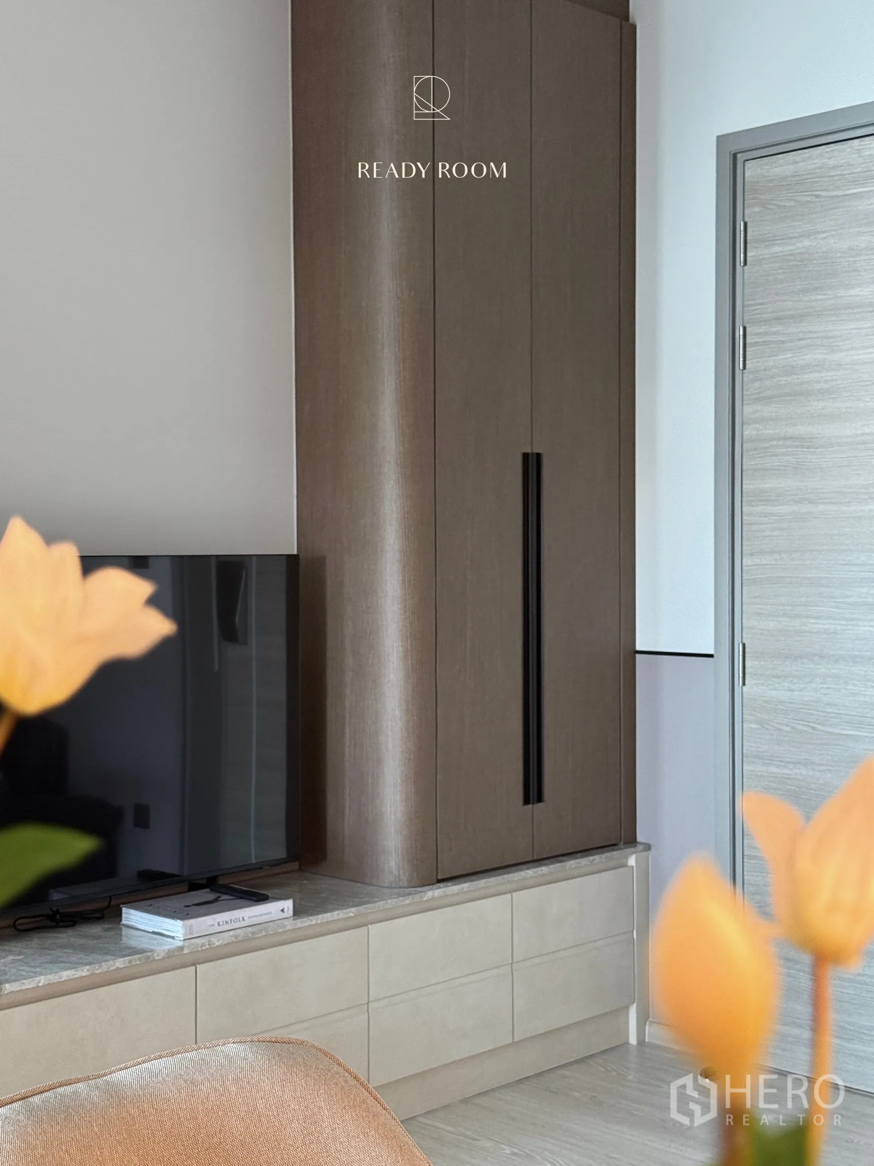 Condominium for rent in Khlong Toei, Bangkok - TV on a low storage cabinet with a tall built-in cupboard detail.