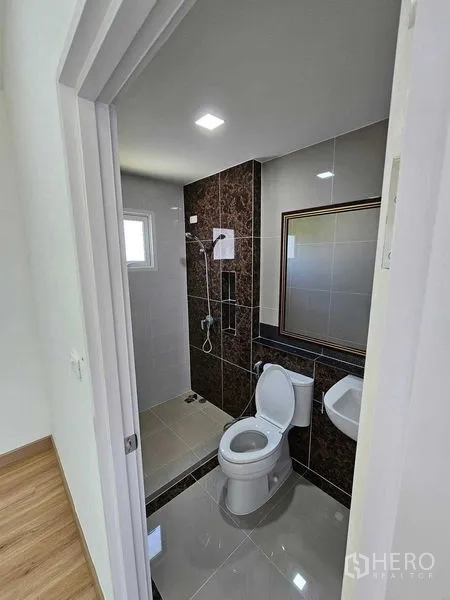 Detached House for rent in Thanyaburi, Pathum Thani - Second bathroom with shower zone, toilet and framed mirror