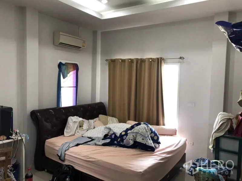 Detached House for sale in Lam Luk Ka, Pathum Thani - Cozy bedroom with bed and beige curtains.