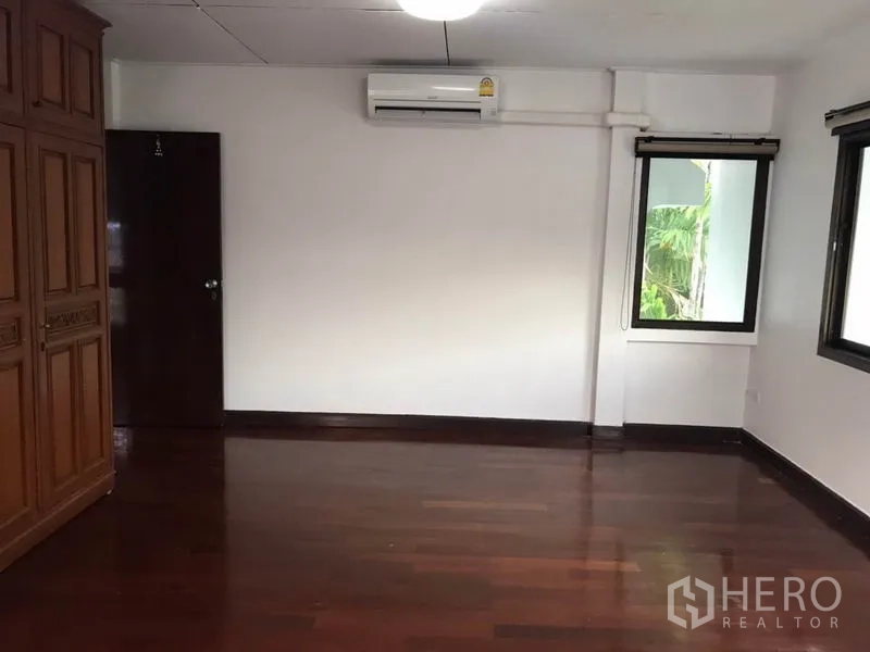 独立式住宅 出租在Phra Khanong, Bangkok - 大卧室，深色木地板，内置衣柜，窗户及空调。