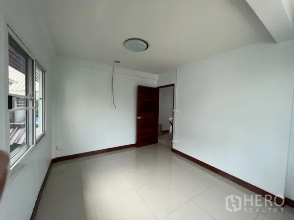 独立式住宅 出租在Khlong Toei, Bangkok - 明亮空房，白色墙面，光亮瓷砖地面，配窗户与木门。