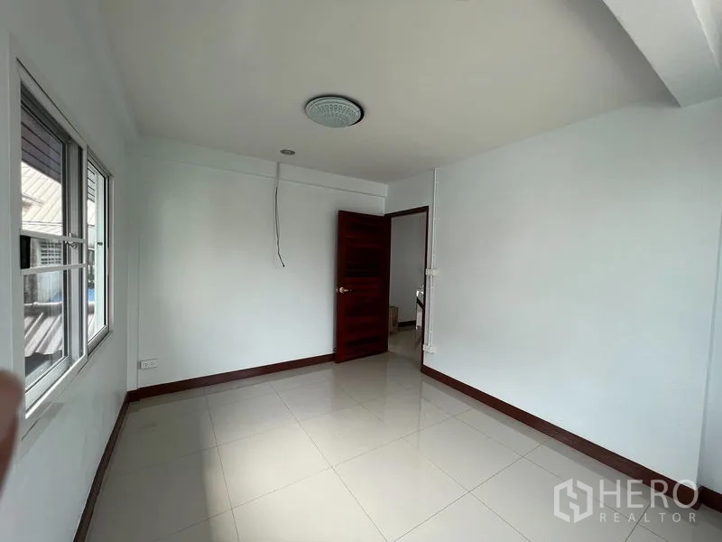 独立式住宅 出租在Khlong Toei, Bangkok - 明亮空房，白色墙面，光亮瓷砖地面，配窗户与木门。