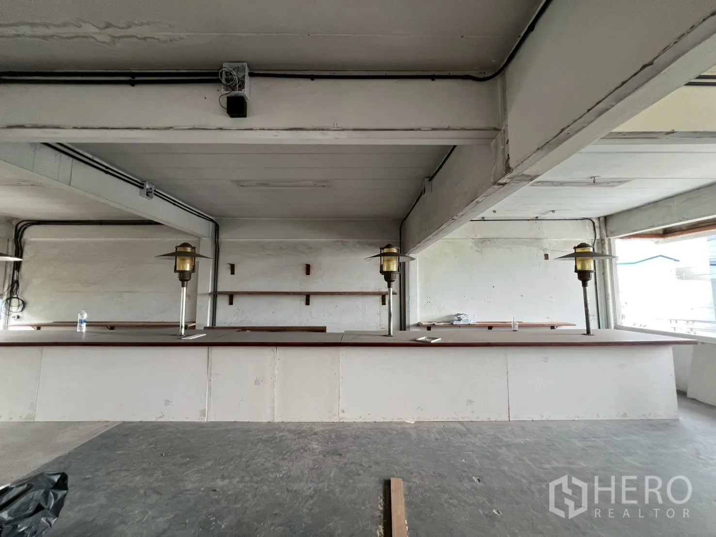 Retail Space for rent in Watthana, Bangkok - Front view of extended bar counter with built-in wall shelves and industrial ceiling in Bangkok retail unit.