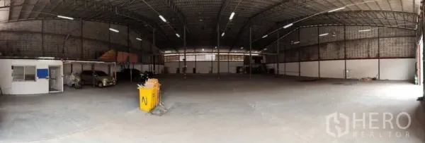 Warehouse for rent in Bang Phli, Samut Prakan - Wide warehouse interior with high steel roof, LED lighting, concrete floor and a small office area on the left.