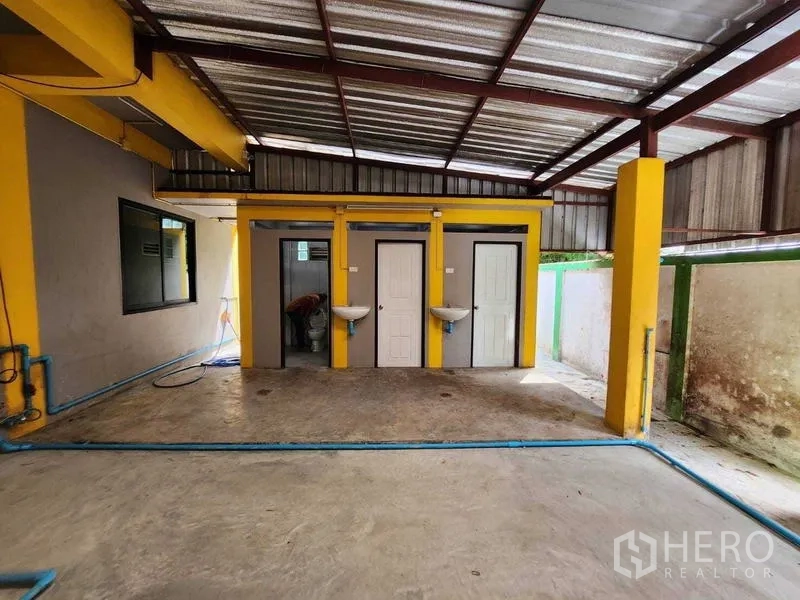 Warehouse for rent in Lat Krabang, Bangkok - Row of restroom doors with hand basins in the warehouse service zone.