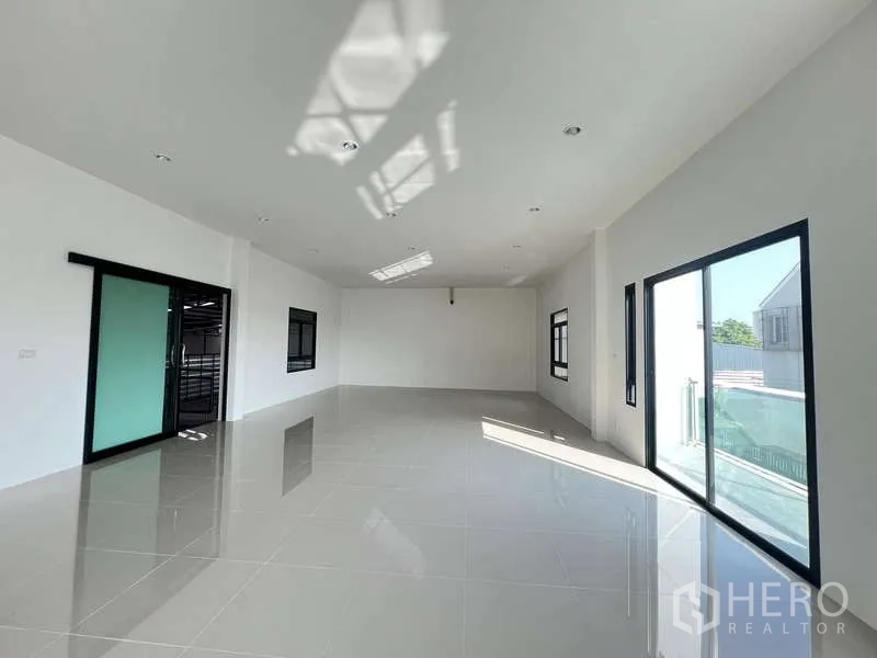 Warehouse for rent or sale - Spacious office area with skylight, sliding glass door and black‑framed windows.