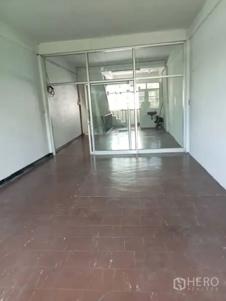 店屋 出租在Phra Khanong, Bangkok - 楼上房间，棕色地砖，整面玻璃隔断并连接楼梯区域。