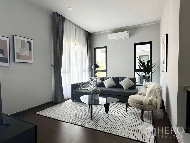 Detached House for rent in Bang Phli, Samut Prakan - Cozy family lounge with gray sofa, round coffee table and large windows.