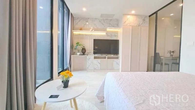 Condominium for rent or sale in Pathum Wan, Bangkok - Bedroom with large windows, TV console and wardrobe finished in marble patterns.