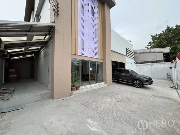 Warehouse for rent or sale in Wang Thonglang, Bangkok - Driveway with covered loading bay beside the warehouse, car parked at front.