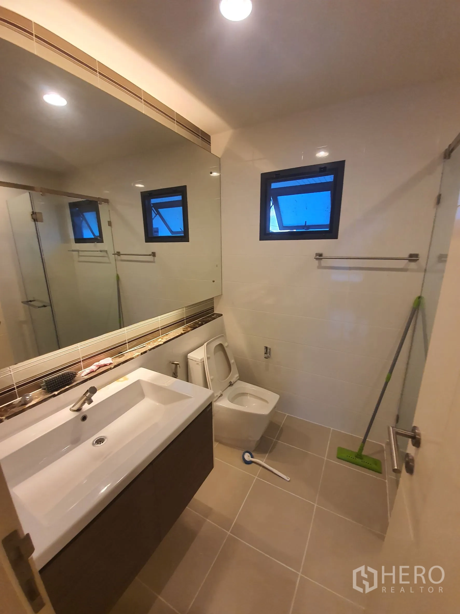 Detached House for rent in Bang Kapi, Bangkok - Upstairs bathroom with large mirror, glass shower and modern fixtures.