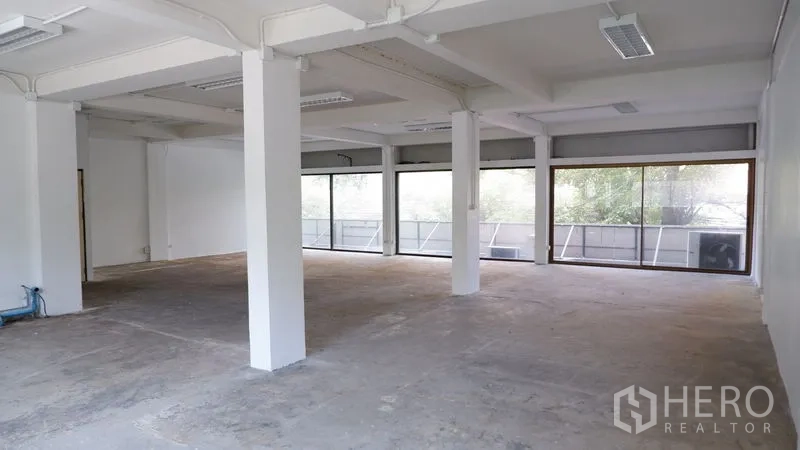 Office Space for rent in Watthana, Bangkok - Open-plan office floor with multiple columns, ceiling lighting, and glass frontage.