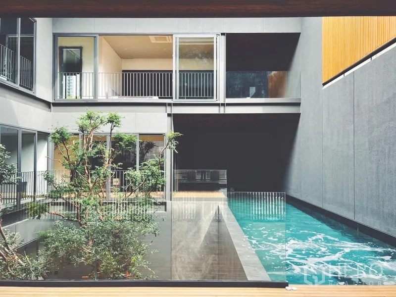 Detached House for rent or sale in Bangkok - Long lap pool beside glass railing and courtyard greenery.