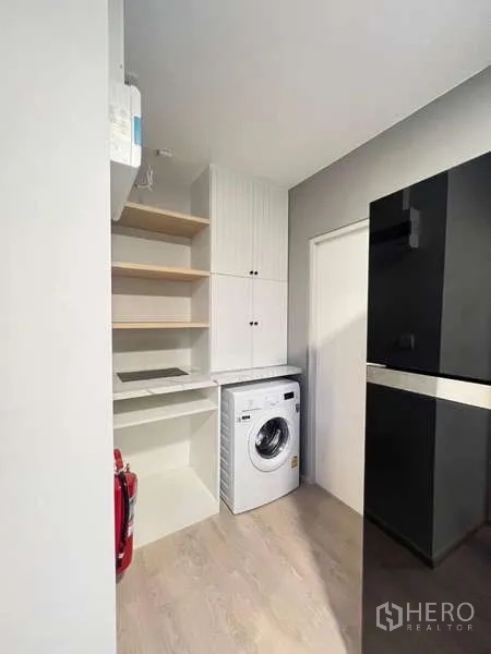 Detached House for rent in Prawet, Bangkok - Compact utility kitchen with shelving, cabinets, refrigerator and washing machine.