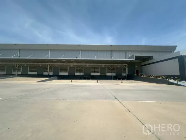 Warehouse for rent in Bang Phli, Samut Prakan - Row of dock-high loading bays with roller shutter doors and sheltered platform.