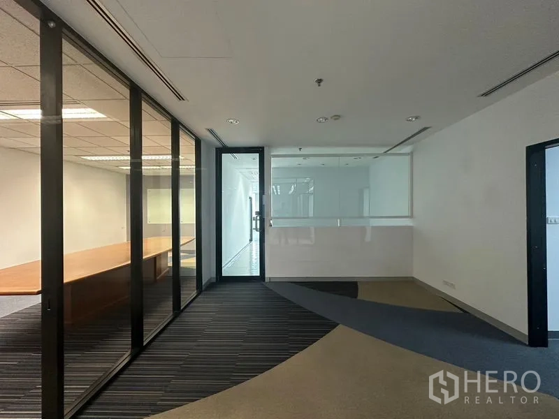 Office Space for rent in Khlong Toei, Bangkok - Entrance corridor with glass partitions and meeting room visible through the panels.