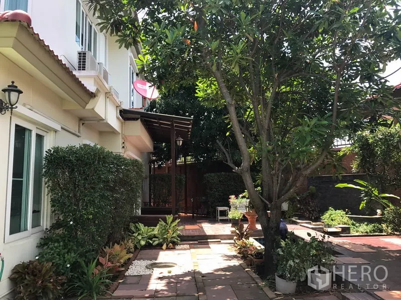 บ้าน ขายในPak Kret, Nonthaburi - ลานข้างบ้านปูพื้นกระเบื้อง มีต้นไม้ใหญ่และกันสาด
