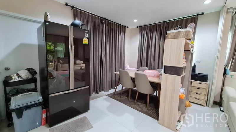 Detached House for sale in Samut Prakan - Dining corner next to the kitchen with a four-seat table and large curtains.