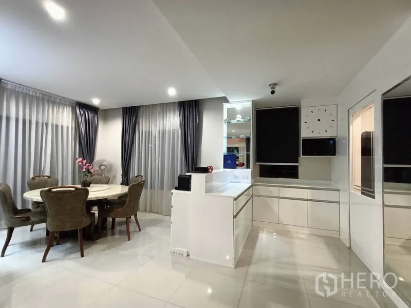 Detached House for rent - Dining area with round table, sheer curtains and built-in cabinetry.