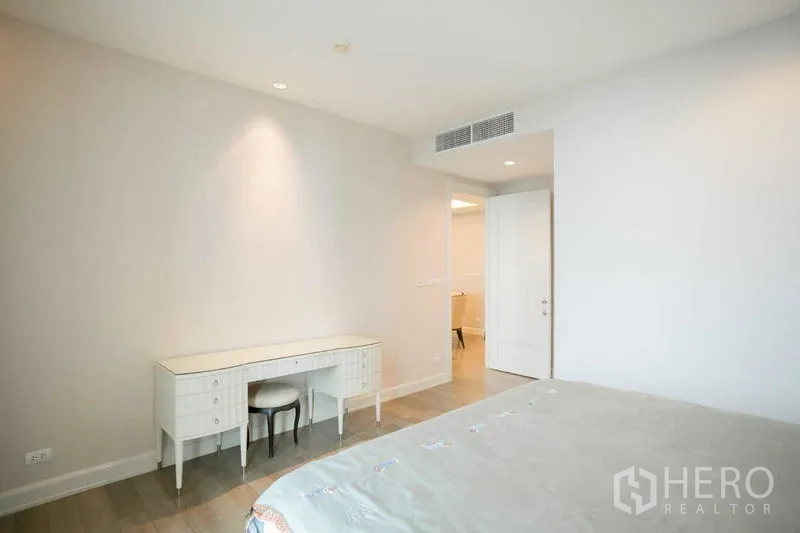 Condominium for rent or sale in Pathum Wan, Bangkok - Minimalist bedroom with built-in desk, stool and light wood flooring.