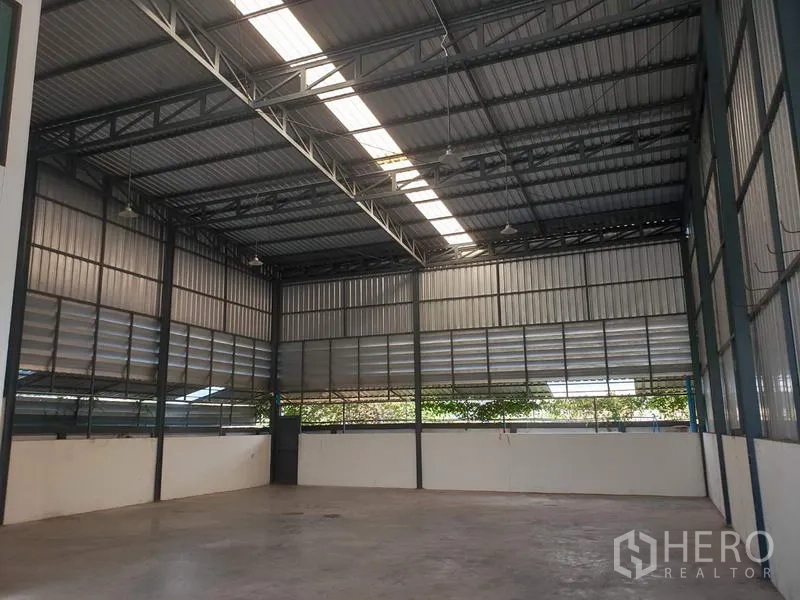 Factory for rent or sale in Lam Luk Ka, Pathum Thani - High-ceiling warehouse interior with steel structure, skylight strip and ventilated metal cladding.