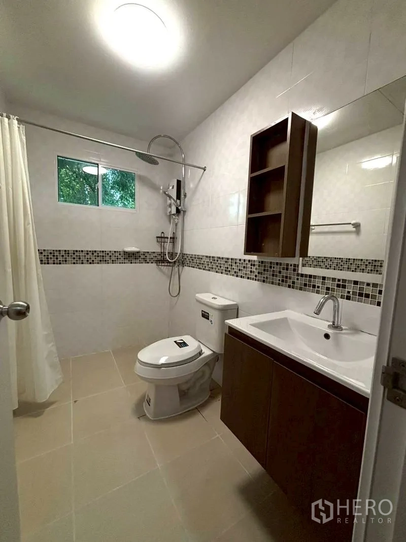 Townhouse for rent in Suan Luang, Bangkok - Bathroom with vanity, toilet, rain shower, and tiled walls.