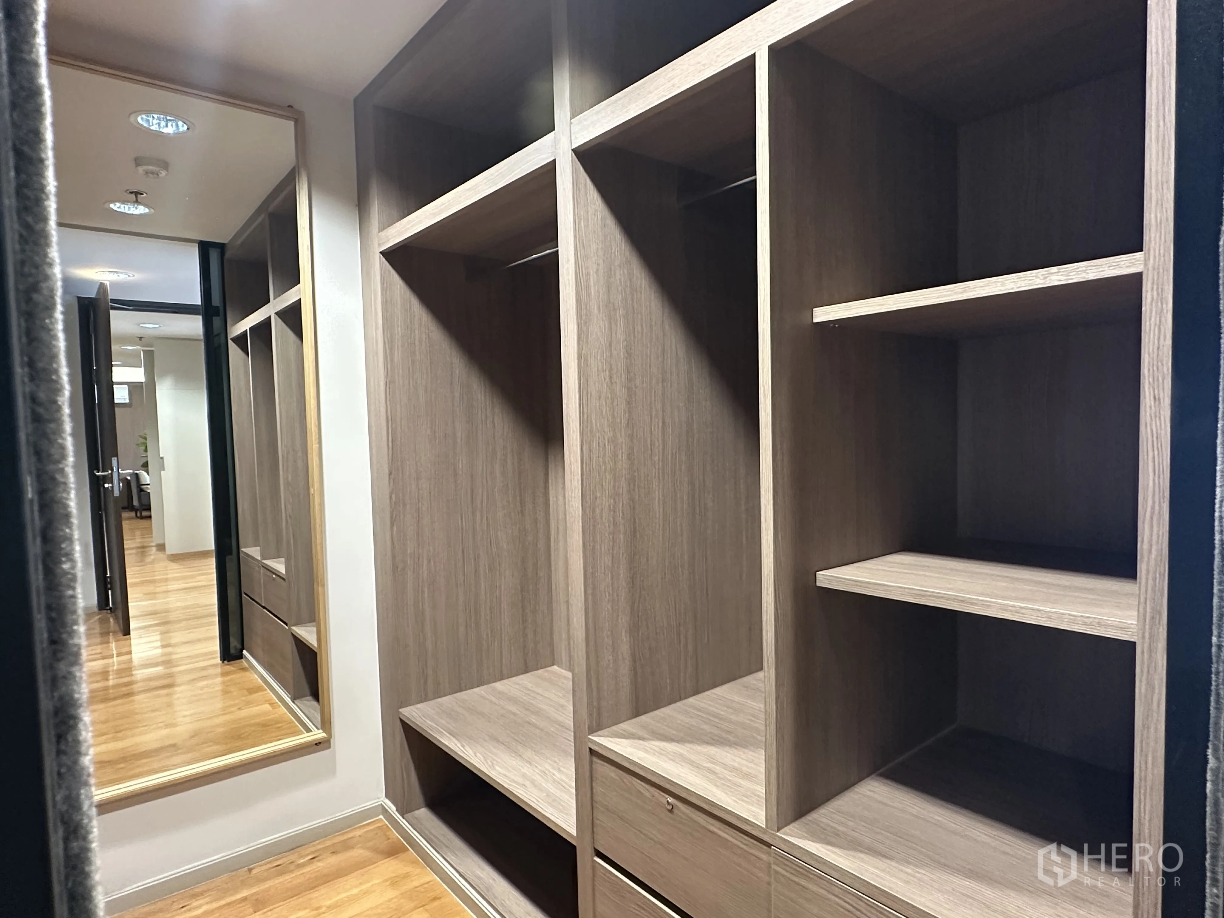 Condominium for rent in Khlong Toei, Bangkok - Walk-in closet with custom wood cabinetry and full-height mirror.