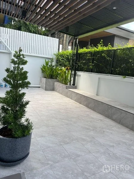 独立式住宅 出租在Suan Luang, Bangkok - 户外瓷砖庭院，种植池与私密围栏、格栅顶。