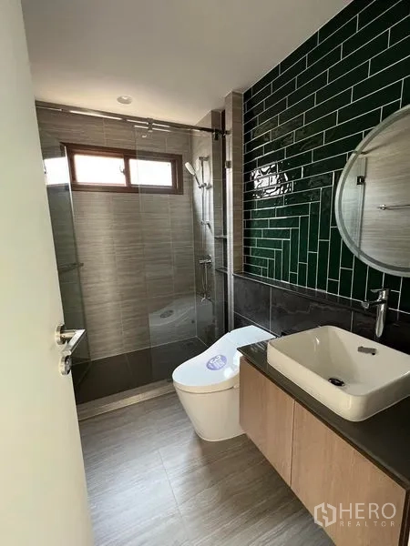 Detached House for rent in Bang Kapi, Bangkok - Bathroom with green subway-tile wall, vanity, and glass shower.