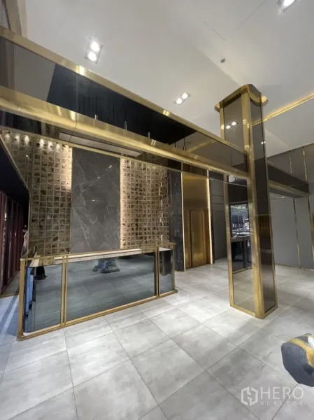 Shophouse for rent in Phra Khanong, Bangkok - Reception area with marble and mirrored finishes framed by brass details.