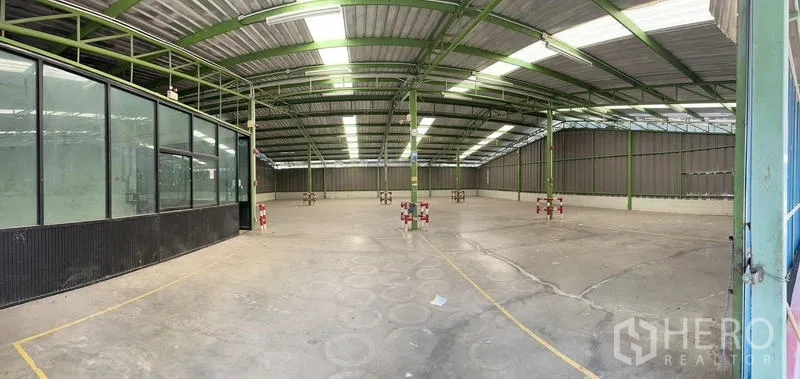 Warehouse for rent in Prawet, Bangkok - Large clear-span warehouse bay with green steel framing and skylights.