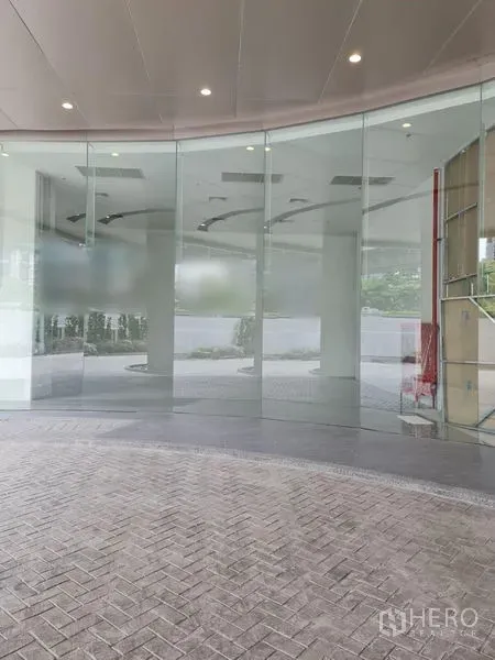 Retail Space for rent - Curved floor-to-ceiling glass storefront of a ground-floor retail unit with covered drop-off area.