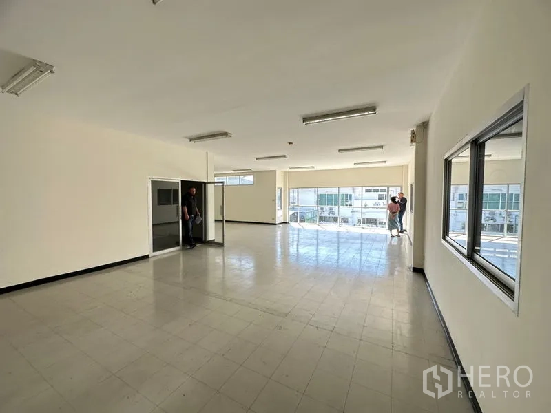 Factory for rent in Si Racha, Chon Buri - Spacious upstairs office with large windows, tiled flooring and fluorescent lighting overlooking the parking area.