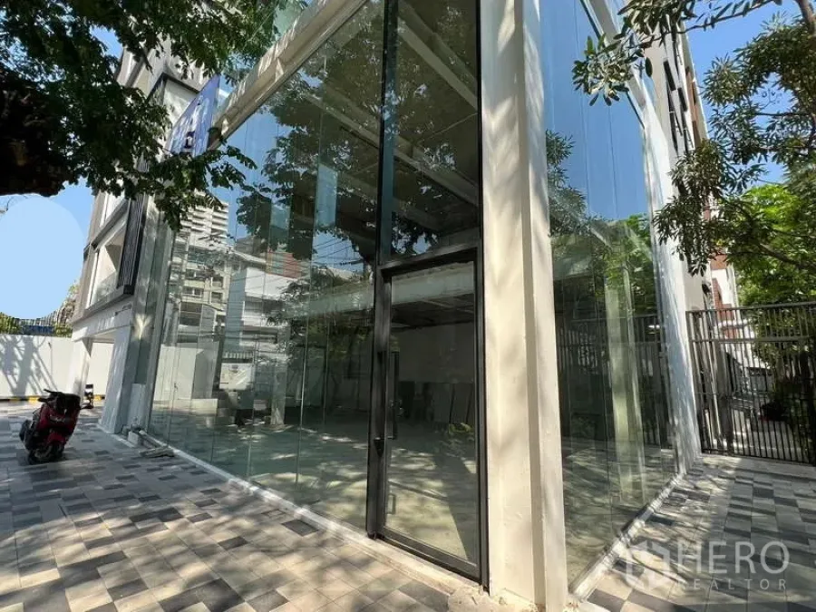 零售空间 出租在Watthana, Bangkok - 转角临街店铺，通高落地玻璃立面与树荫步道。