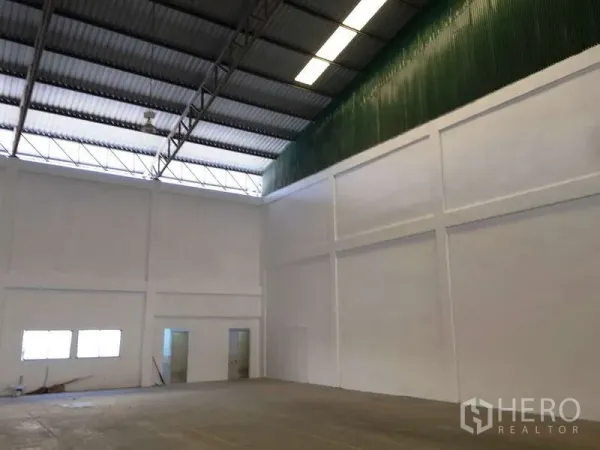 工厂 出租在Bang Bo, Samut Prakan - 室内一角设绿色通风墙，旁有办公室与卫生间门。