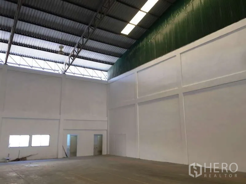 工厂 出租在Bang Bo, Samut Prakan - 室内一角设绿色通风墙，旁有办公室与卫生间门。