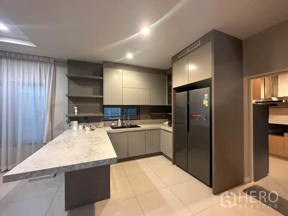 Detached House for rent in Bang Kapi, Bangkok - Sleek Western kitchen featuring grey cabinetry, marble counters and a double-door fridge.