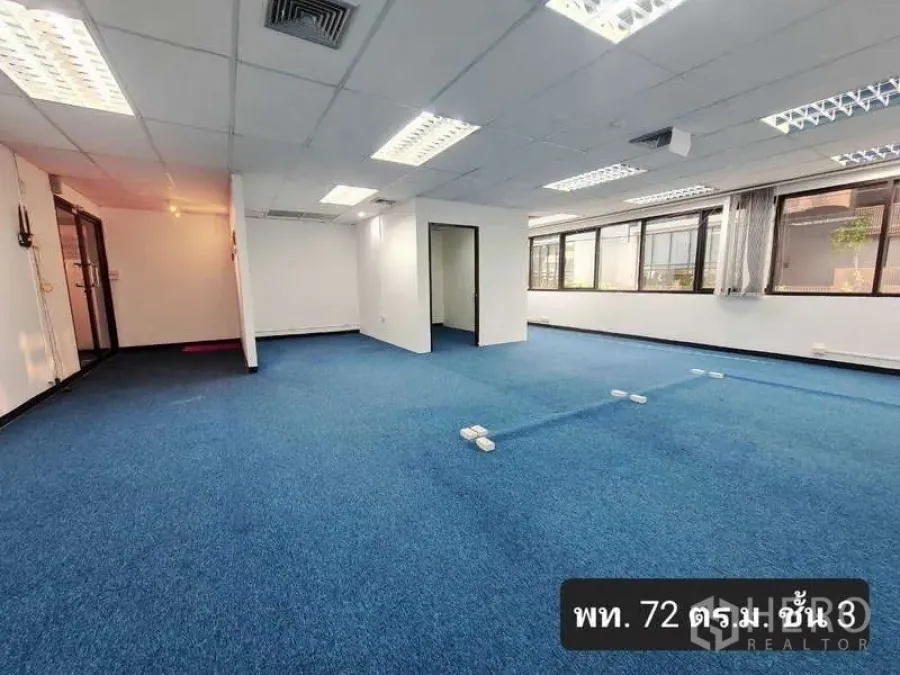 Office Space for rent in Khlong Toei, Bangkok - Open-plan office with blue carpet, glass entry, and a private room; approximately 72 sqm.