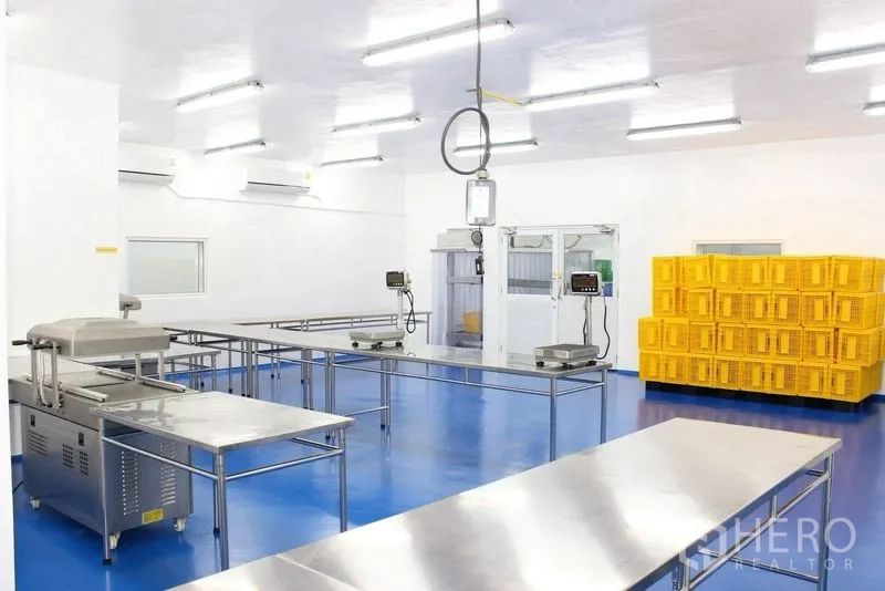 Factory for rent or sale in Krathum Baen, Samut Sakhon - Production space with suspended scale, vacuum sealer, and stacks of yellow crates.