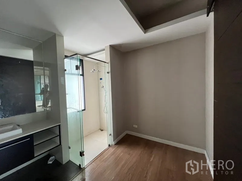 Townhouse for rent or sale in Khlong Toei, Bangkok - Compact bedroom corner with a vanity and an ensuite glass shower.