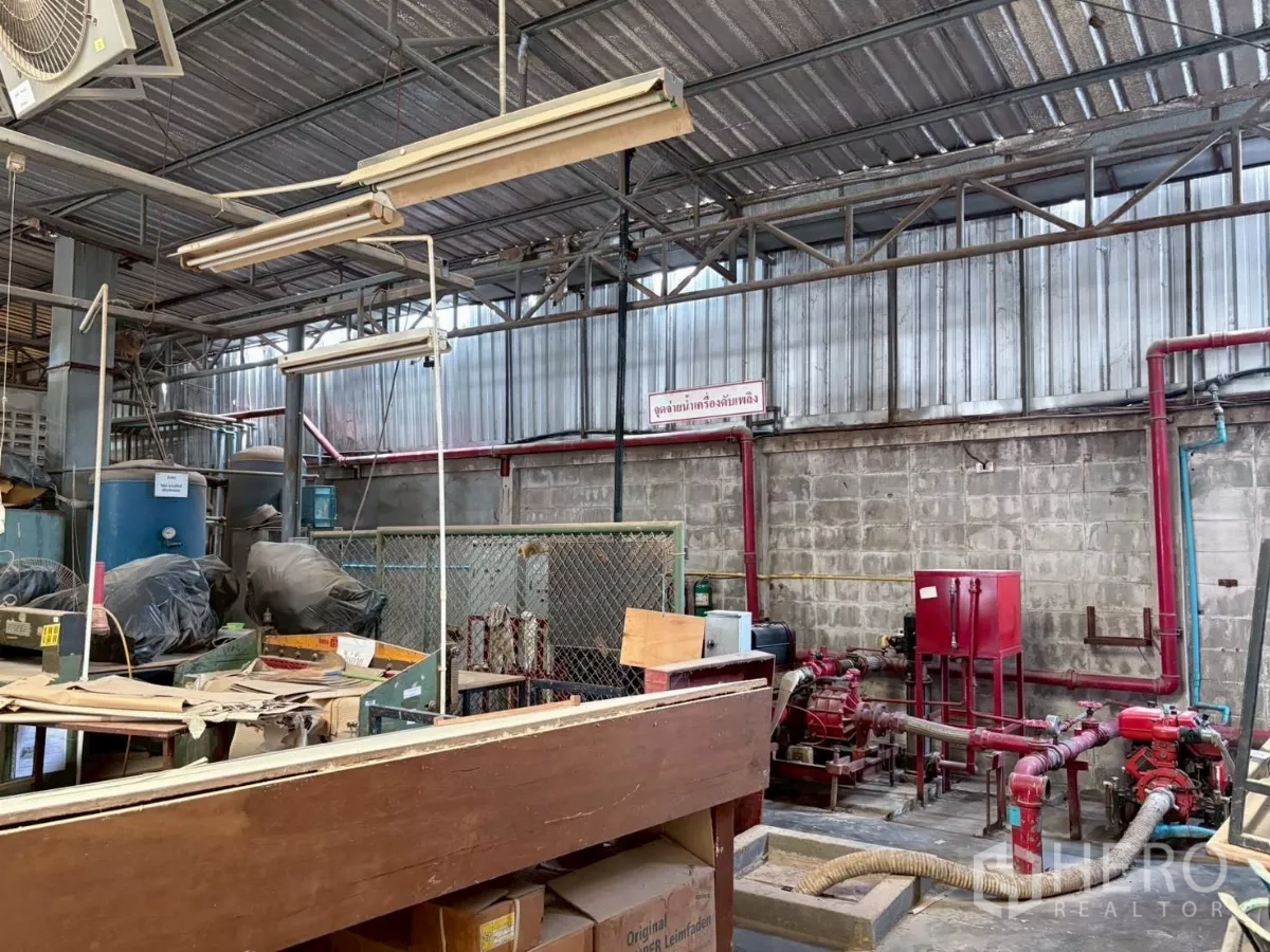Factory for rent or sale in Bang Khun Thian, Bangkok - Interior area showing fire pump piping, valves and storage within the workshop.