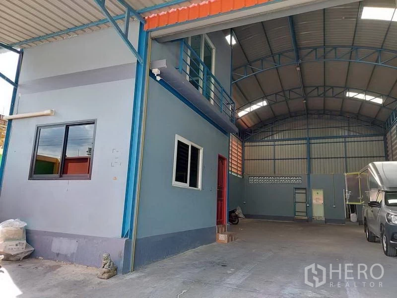 Warehouse for rent or sale in Bang Bua Thong, Nonthaburi - Covered loading area beside a two-storey office block allowing easy truck access.