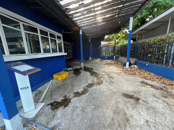 Retail Space for rent in Watthana, Bangkok - Covered outdoor walkway beside blue walls with a service counter and concrete floor.