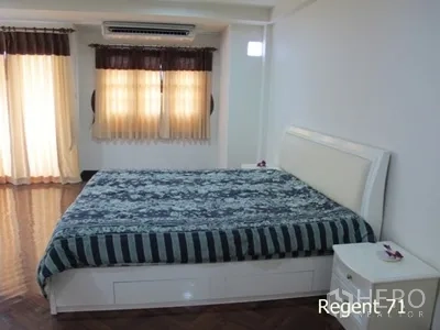 Townhouse for rent in Khlong Toei, Bangkok - Spacious bedroom with a king bed, wood flooring, air conditioning, and soft curtains.