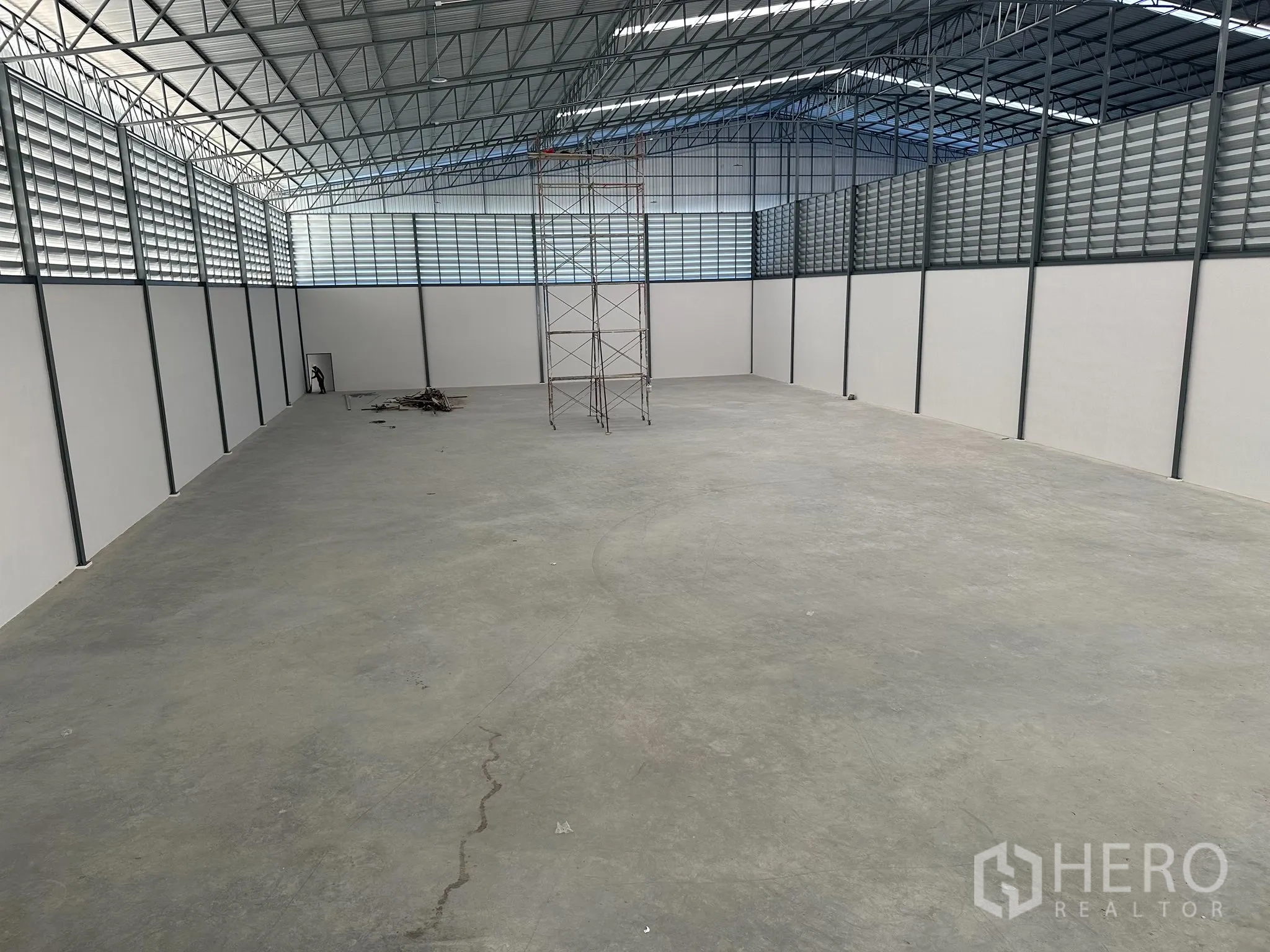 Factory for rent in Nong Khaem, Bangkok - Spacious interior with louvered upper walls, scaffolding and durable concrete slab suitable for heavy loads.