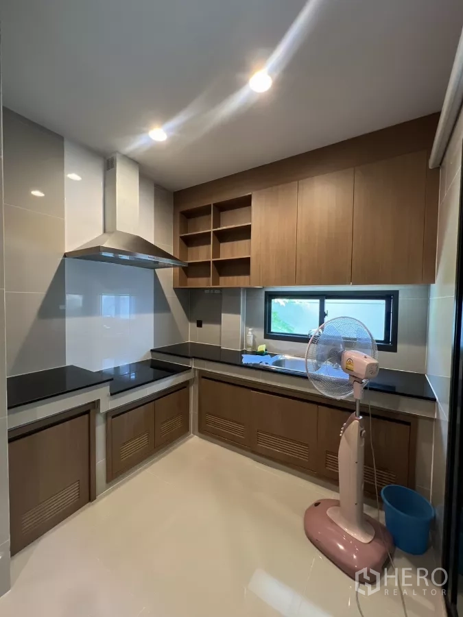 Detached House for rent in Bang Kapi, Bangkok - Another angle of the fitted kitchen showing upper cabinets and bright task lighting.