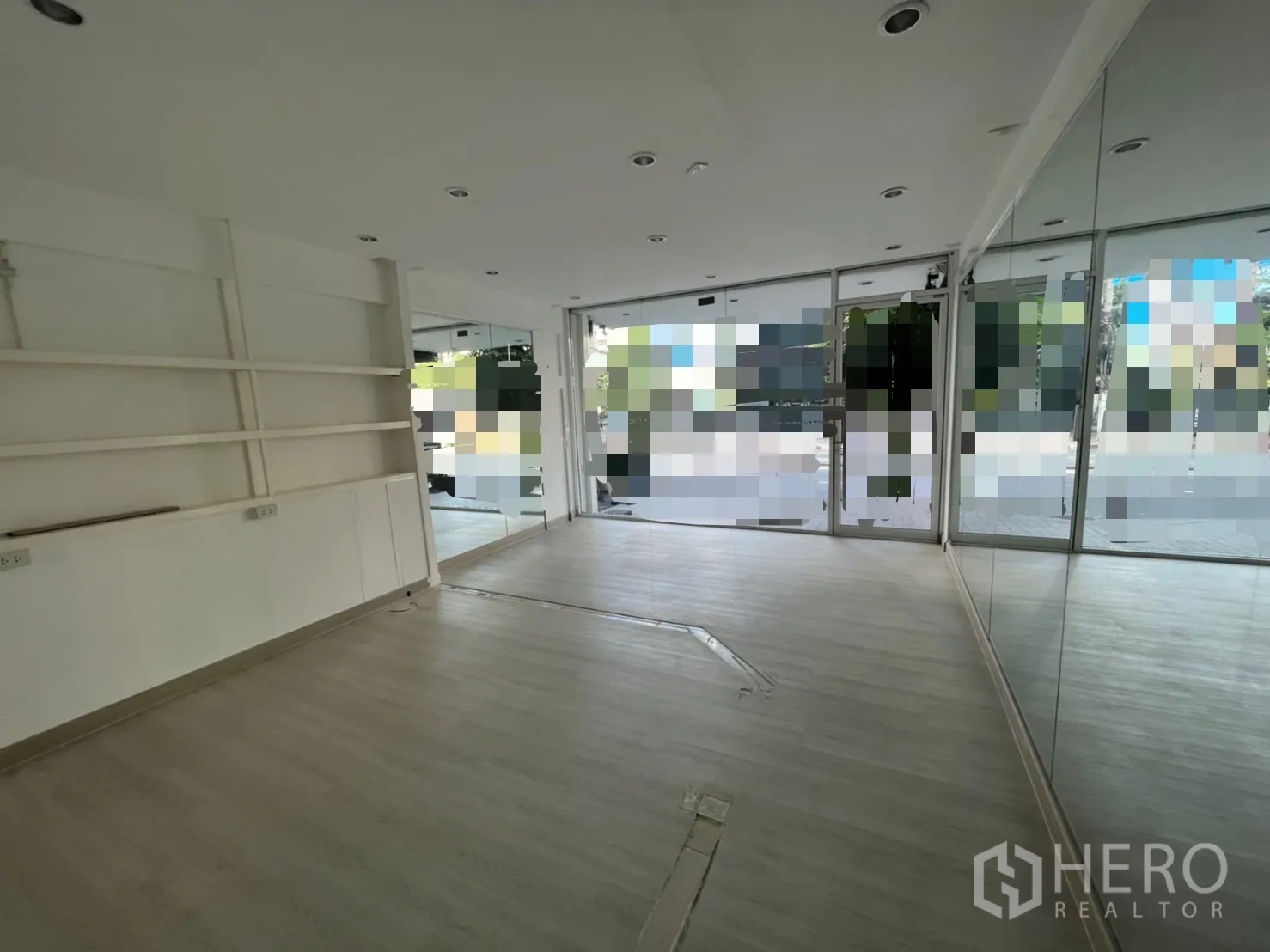 Retail Space for rent in Bangkok - Bright showroom with full-height windows, wall shelving and mirrored feature wall