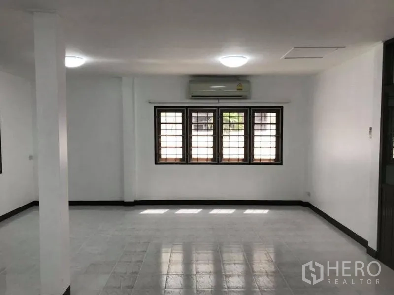 独立式住宅 出租在Khlong Toei, Bangkok - 宽敞客厅，白色地砖，大窗和空调