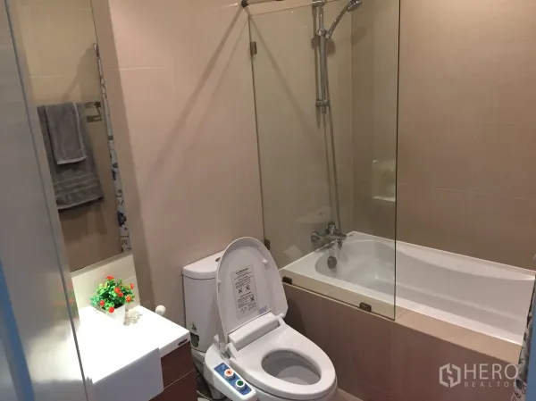 Condominium for rent in Bangkok - Contemporary bathroom with bathtub, glass shower screen, vanity and bidet toilet.